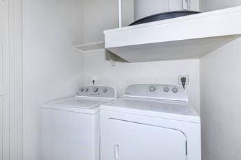 A white washing machine and dryer in a small laundry room.